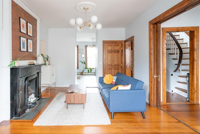 175 Liberty St, Newburgh, NY 12550 - living room featuring wood finished floors, stairway, and a chandelier