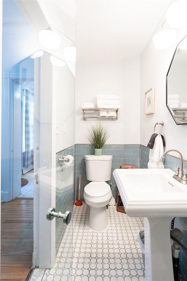 175 Liberty St, Newburgh, NY 12550 - half bathroom featuring toilet, tile walls, a wainscoted wall, and tile patterned floors