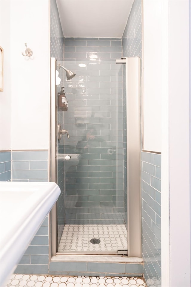 175 Liberty St, Newburgh, NY 12550 - full bathroom with tile walls, a shower stall, tile patterned flooring, and a wainscoted wall