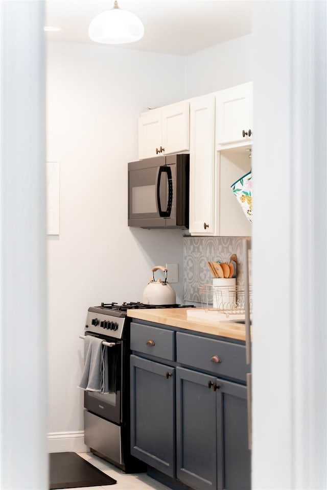 175 Liberty St, Newburgh, NY 12550 - kitchen featuring black microwave, stainless steel gas stove, gray cabinets, butcher block counters, and white cabinets