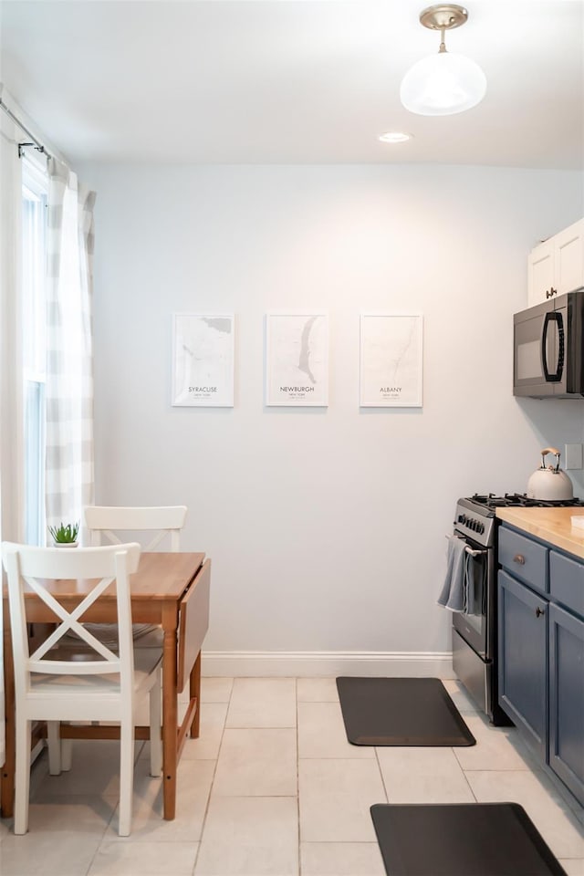 175 Liberty St, Newburgh, NY 12550 - kitchen featuring black microwave, stainless steel range with gas cooktop, baseboards, and light tile patterned flooring