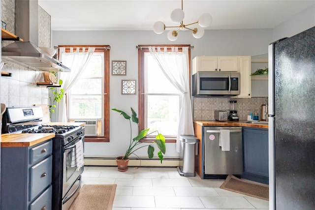 175 Liberty St, Newburgh, NY 12550 - kitchen featuring butcher block counters, appliances with stainless steel finishes, wall chimney exhaust hood, decorative backsplash, and a chandelier