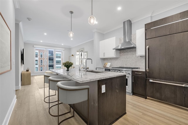 100 Garvies Point Rd Unit 1238, Glen Cove, NY 11542 - kitchen featuring wall chimney range hood, high end stainless steel range oven, refrigerator, a sink, and crown molding