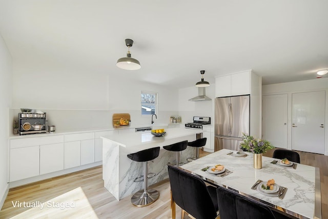 2939 N Wading River Rd, Wading River, NY 11792 - kitchen with stainless steel appliances, modern cabinets, wall chimney range hood, and white cabinetry