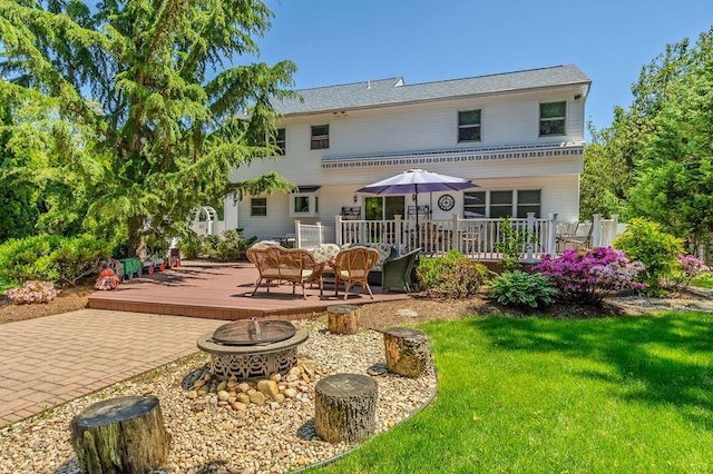 4 Pak Ct, East Setauket, NY 11733 - rear view of property with a fire pit, a deck, and a lawn