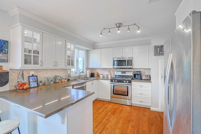 8 Country Ln, Warwick, NY 10990 - kitchen featuring appliances with stainless steel finishes, a peninsula, glass insert cabinets, white cabinetry, and ornamental molding