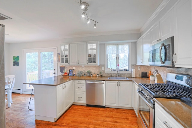 8 Country Ln, Warwick, NY 10990 - kitchen featuring appliances with stainless steel finishes, a peninsula, a sink, healthy amount of natural light, and ornamental molding