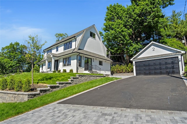 2 Henry St, Great Neck, NY 11023 - view of front of house featuring stucco siding, a detached garage, and a front yard