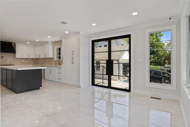 2 Henry St, Great Neck, NY 11023 - kitchen featuring light countertops, tasteful backsplash, ventilation hood, white cabinetry, and a sink