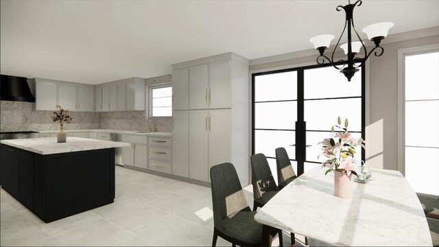 2 Henry St, Great Neck, NY 11023 - kitchen with wall chimney exhaust hood, a chandelier, a kitchen island, hanging light fixtures, and light tile patterned floors