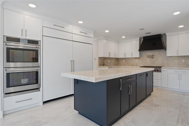 2 Henry St, Great Neck, NY 11023 - kitchen with custom exhaust hood, stainless steel appliances, light marble finish flooring, white cabinetry, and backsplash