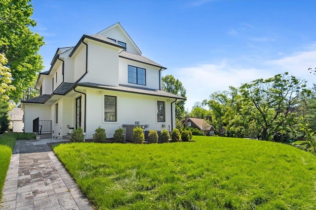 2 Henry St, Great Neck, NY 11023 - rear view of house featuring stucco siding and a yard