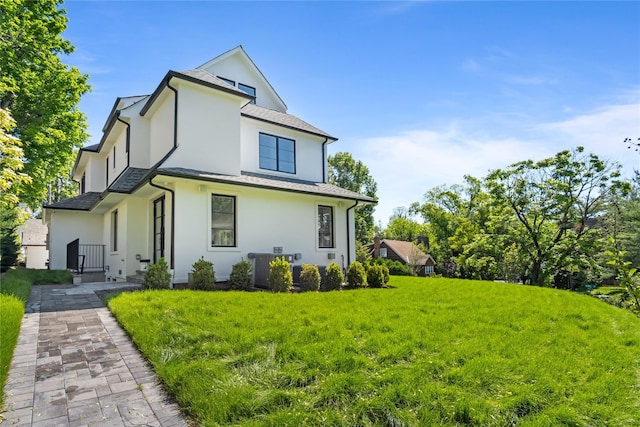 2 Henry St, Great Neck, NY 11023 - back of house featuring stucco siding and a lawn