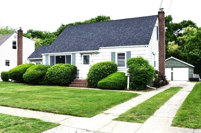 465 18th St, West Babylon, NY 11704 - cape cod house featuring an outbuilding, a front yard, a detached garage, a shingled roof, and a chimney
