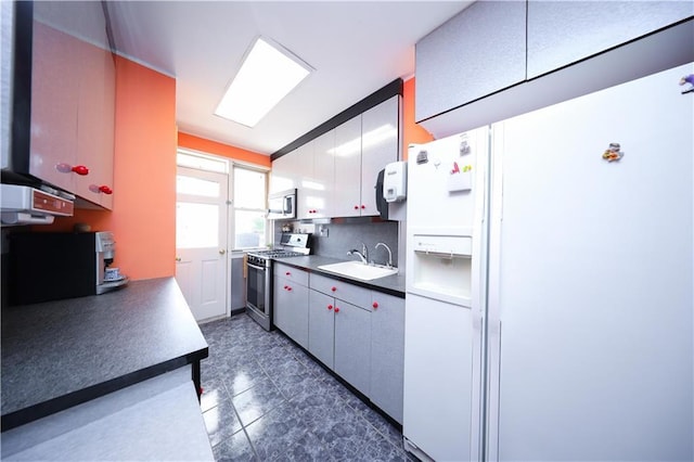 2179 E 26th St, Brooklyn, NY 11229 - kitchen featuring stainless steel appliances, a sink, backsplash, and dark countertops