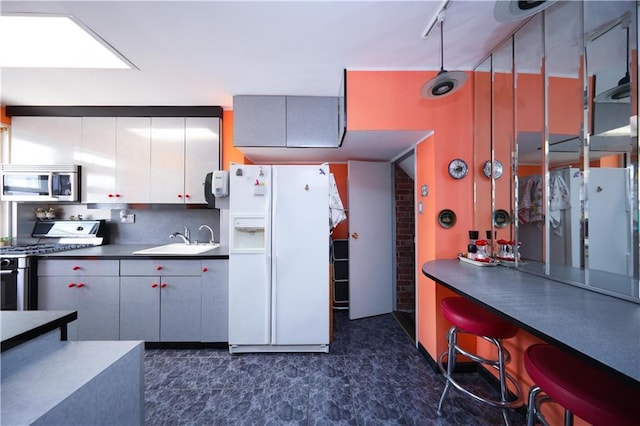 2179 E 26th St, Brooklyn, NY 11229 - kitchen with stainless steel appliances, a sink, dark countertops, and decorative backsplash