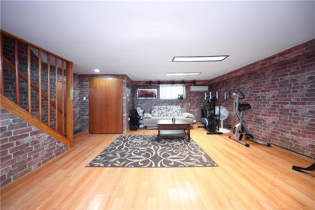 2179 E 26th St, Brooklyn, NY 11229 - living room featuring brick wall, wood finished floors, and stairway