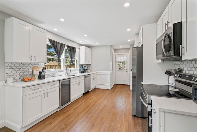 170 Lenox St, Port Jefferson Station, NY 11776 - kitchen featuring appliances with stainless steel finishes, wine cooler, a sink, light wood-style floors, and recessed lighting