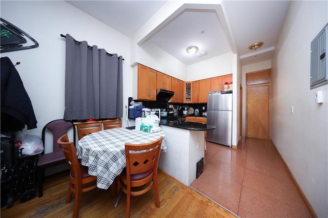462 52nd St Unit 2D, Brooklyn, NY 11220 - kitchen with freestanding refrigerator, dark countertops, a peninsula, glass insert cabinets, and brown cabinets