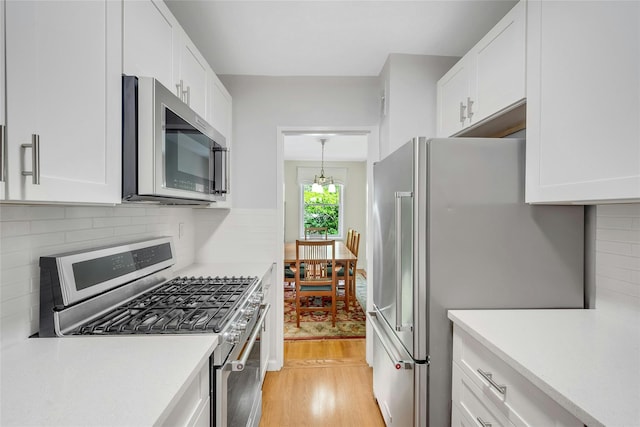 177 E Hartsdale Ave Unit 5L, Hartsdale, NY 10530 - kitchen featuring stainless steel appliances, light countertops, light wood-style floors, and white cabinets
