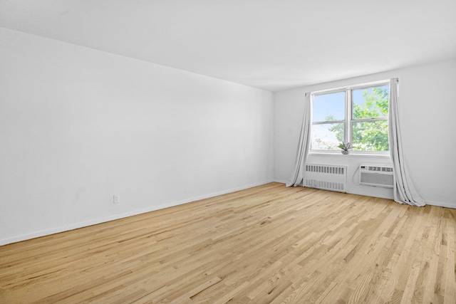 642 Locust St Unit 3K, Mount Vernon, NY 10552 - spare room with radiator heating unit, wood finished floors, baseboards, and a wall mounted air conditioner