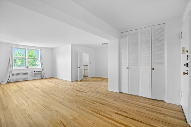 642 Locust St Unit 3K, Mount Vernon, NY 10552 - unfurnished living room featuring light wood-style floors, radiator heating unit, and a wall mounted air conditioner