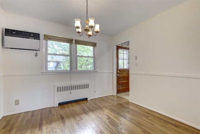 29 Newmarket Rd, Syosset, NY 11791 - spare room featuring radiator, an AC wall unit, a chandelier, wood finished floors, and baseboards