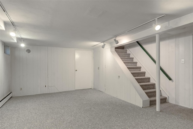 29 Newmarket Rd, Syosset, NY 11791 - finished basement with rail lighting, stairway, carpet floors, a baseboard heating unit, and wooden walls