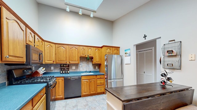 235 Panorama Ct, Poughkeepsie, NY 12603 - kitchen with stainless steel appliances, a high ceiling, a sink, backsplash, and light tile patterned floors