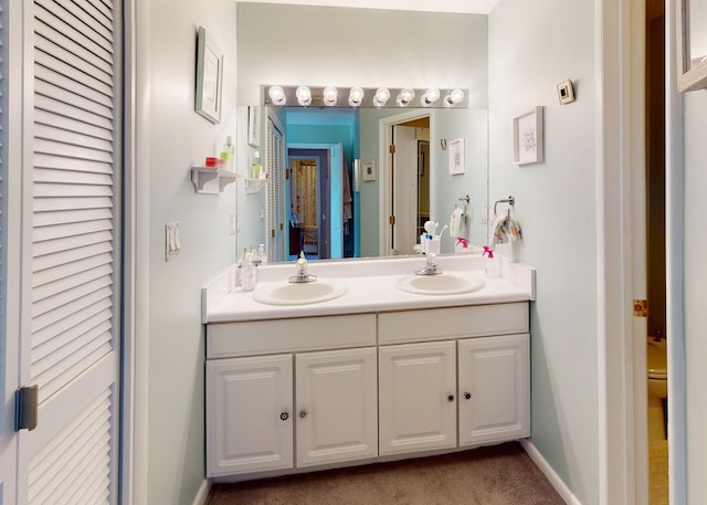 235 Panorama Ct, Poughkeepsie, NY 12603 - bathroom featuring double vanity, toilet, a closet, and baseboards