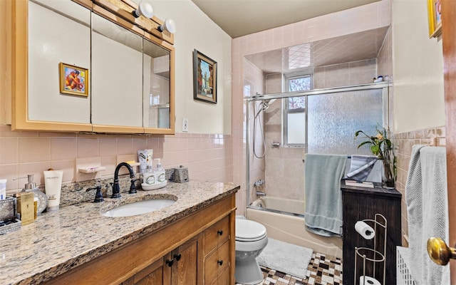 82-60 166th St, Jamaica, NY 11432 - full bath featuring tile walls, vanity, toilet, bath / shower combo with glass door, and decorative backsplash