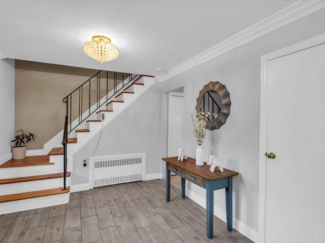 38 Nadine Ln, Port Jefferson Station, NY 11776 - staircase with radiator, baseboards, wood finished floors, ornamental molding, and a chandelier