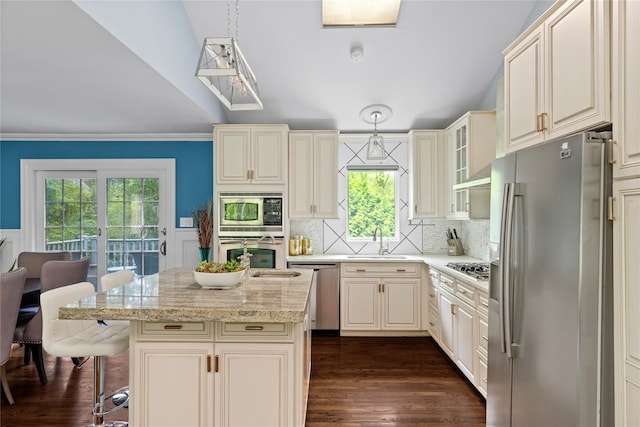 25 Cliff Rd W, Wading River, NY 11792 - kitchen featuring appliances with stainless steel finishes, a sink, dark wood-style floors, a kitchen breakfast bar, and decorative light fixtures