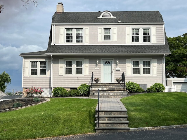 22 Chippewa Rd, Yonkers, NY 10710 - view of front of home with a chimney, a shingled roof, and a front yard