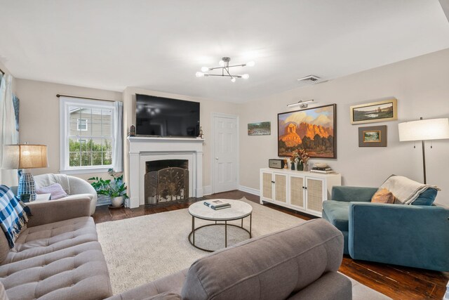 63 Liberty St, Beacon, NY 12508 - living area with dark wood finished floors, a fireplace with flush hearth, a chandelier, and baseboards