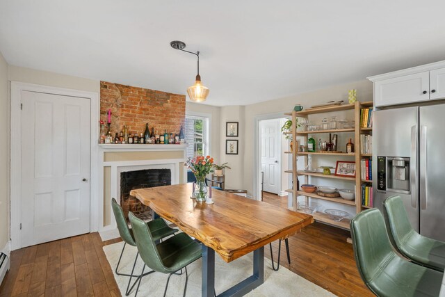 63 Liberty St, Beacon, NY 12508 - dining room featuring hardwood / wood-style flooring, baseboard heating, and a fireplace