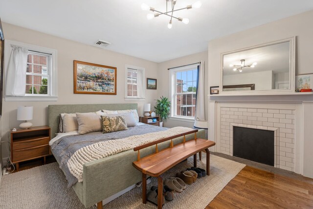 63 Liberty St, Beacon, NY 12508 - bedroom with a chandelier, wood finished floors, and a fireplace