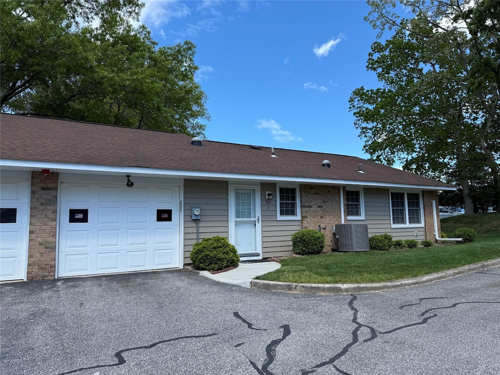 286 Berwick Ct Unit A, Ridge, NY 11961 - view of front of house with cooling unit, an attached garage, driveway, and a front lawn