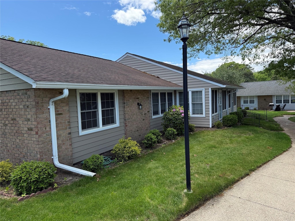 286 Berwick Ct Unit A, Ridge, NY 11961 - ranch-style house featuring a front lawn, roof with shingles, and brick siding