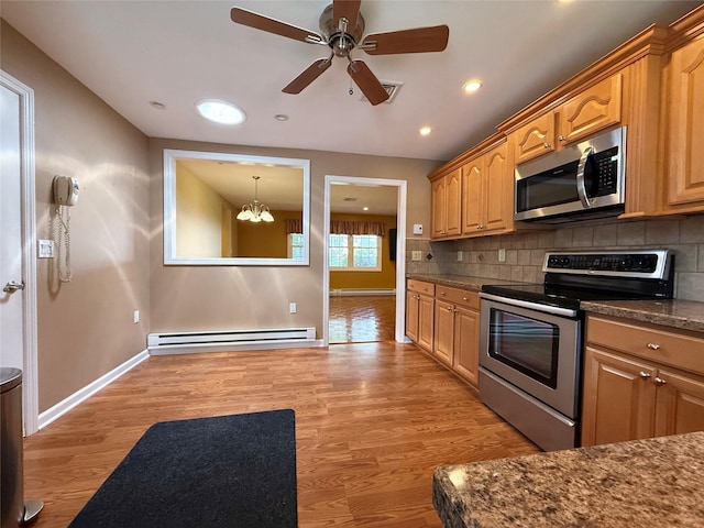 286 Berwick Ct Unit A, Ridge, NY 11961 - kitchen with appliances with stainless steel finishes, a baseboard radiator, a chandelier, light wood-style flooring, and tasteful backsplash