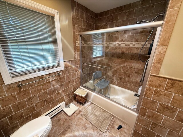 286 Berwick Ct Unit A, Ridge, NY 11961 - full bathroom featuring tile walls, a baseboard heating unit, shower / bath combination with glass door, toilet, and healthy amount of natural light