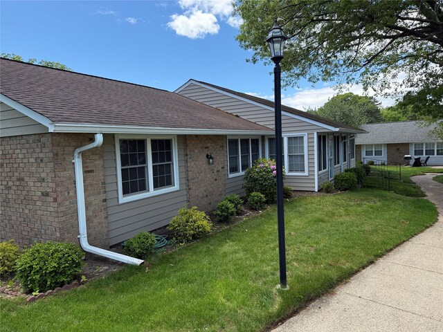 286 Berwick Ct Unit A, Ridge, NY 11961 - ranch-style house with a front lawn, roof with shingles, and brick siding
