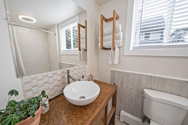 29 Montauk St, Selden, NY 11784 - full bath featuring a baseboard radiator, a shower with shower curtain, vanity, toilet, and decorative backsplash