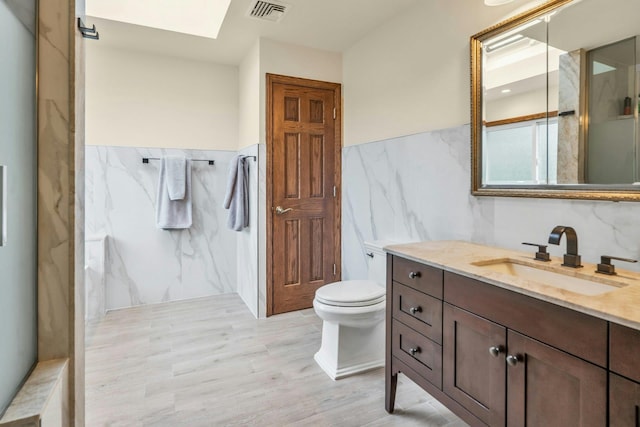 8 Victor Ln, Woodbury, NY 11797 - bathroom featuring tile walls, vanity, a skylight, toilet, and a marble finish shower
