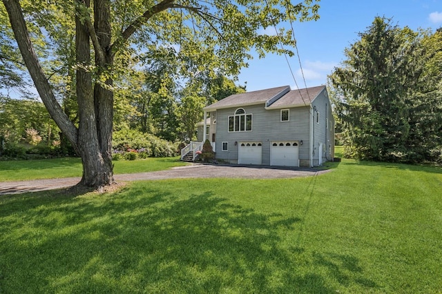 312 Diddell Rd, Poughkeepsie, NY 12603 - back of house featuring an attached garage, asphalt driveway, and a lawn