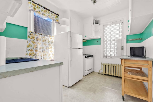 3004 14th St, Astoria, NY 11102 - kitchen with radiator, white appliances, open shelves, white cabinets, and light countertops