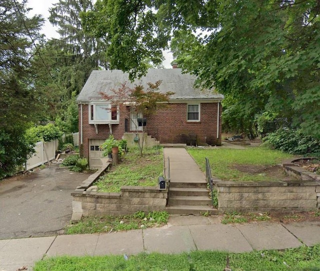 8 W Funston Ave, Spring Valley, NY 10977 - view of front of house featuring brick siding, driveway, a garage, and a chimney