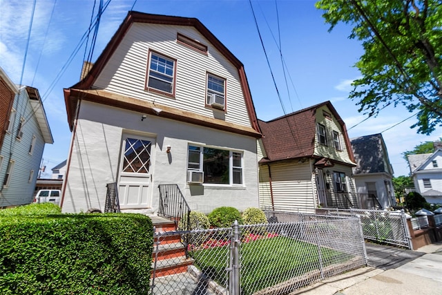4 Oakley Pl, Mount Vernon, NY 10550 - dutch colonial featuring a gambrel roof, a fenced front yard, stucco siding, a gate, and cooling unit