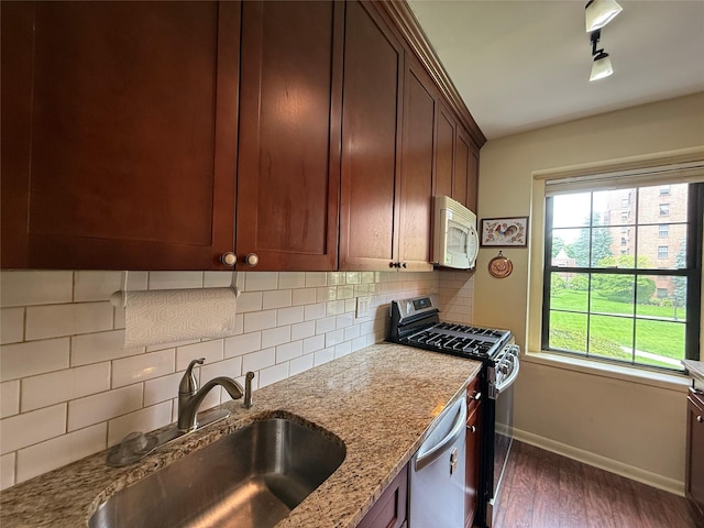 198 Garth Rd Unit 1D, Scarsdale, NY 10583 - kitchen with stainless steel appliances, a sink, baseboards, dark wood-style flooring, and backsplash
