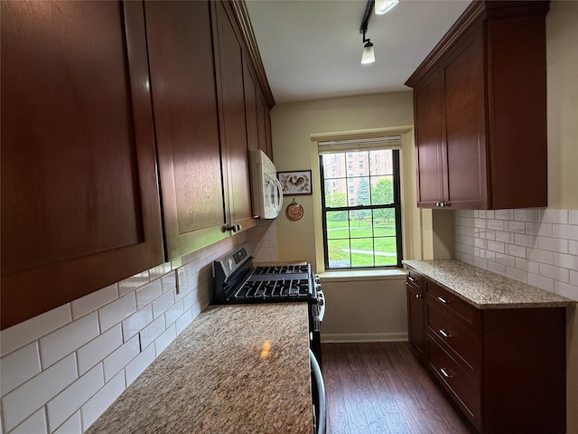 198 Garth Rd Unit 1D, Scarsdale, NY 10583 - kitchen with white microwave, stainless steel gas stove, dark wood-style floors, and decorative backsplash